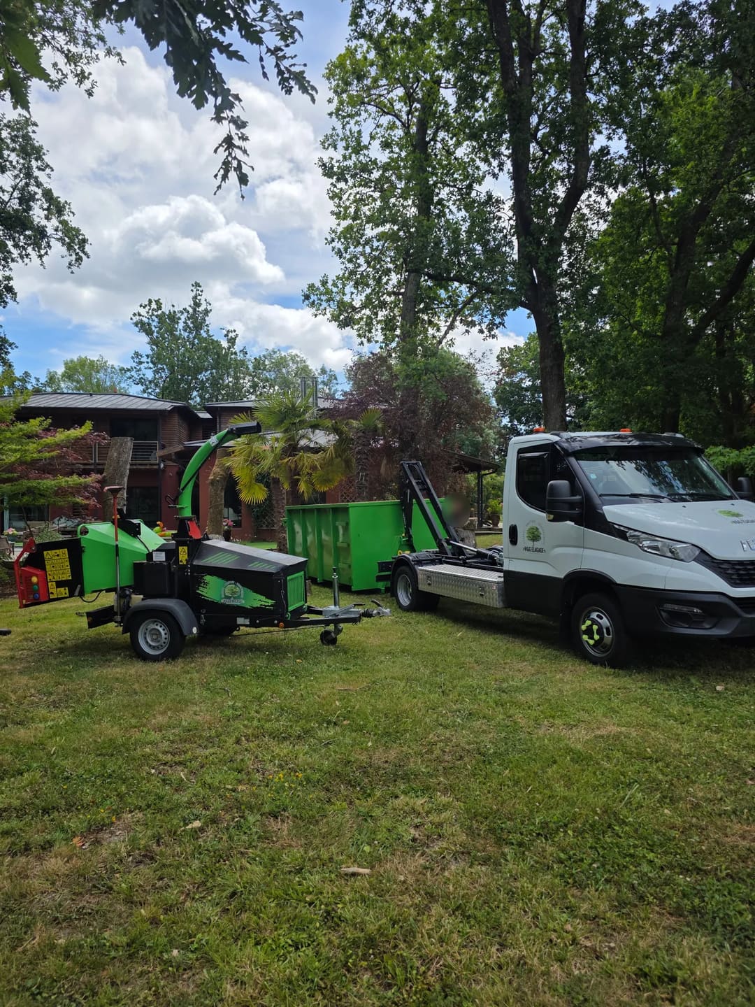 Le camion-benne W&G Élagage et son broyeur de branches garés sur la pelouse d’un parc arboré